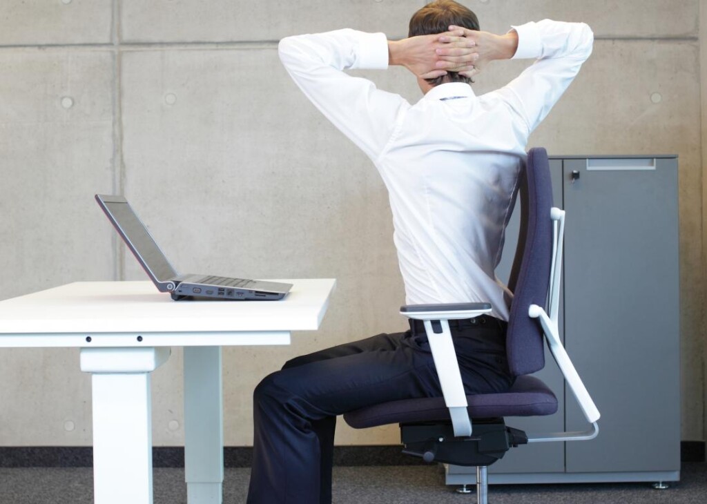 person-seated-on-chair-at-desk-doing-back-twist-stretches