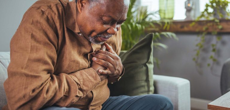 Senior man who suffers, shrinks and has difficulty breathing, chest pain or heart attack during the corona virus pandemic crisis, life insurance. Heart attack symptoms. Senior health care concepts